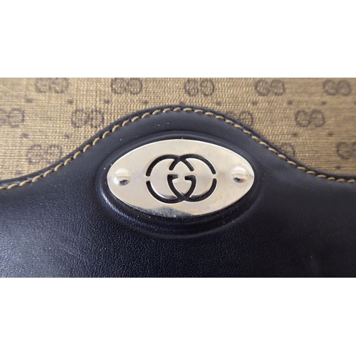 52 - A Gucci black leather and patterned fabric handbag, serial number 104.004.0024