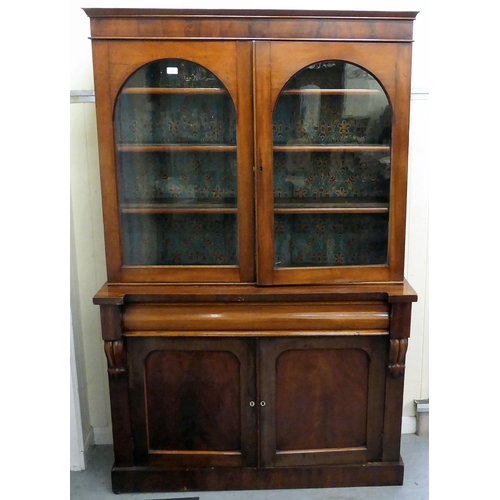 70 - A late Victorian mahogany finished cabinet bookcase, the upper section with two glazed doors, enclos... 