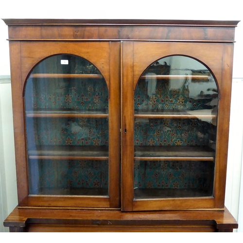 70 - A late Victorian mahogany finished cabinet bookcase, the upper section with two glazed doors, enclos... 