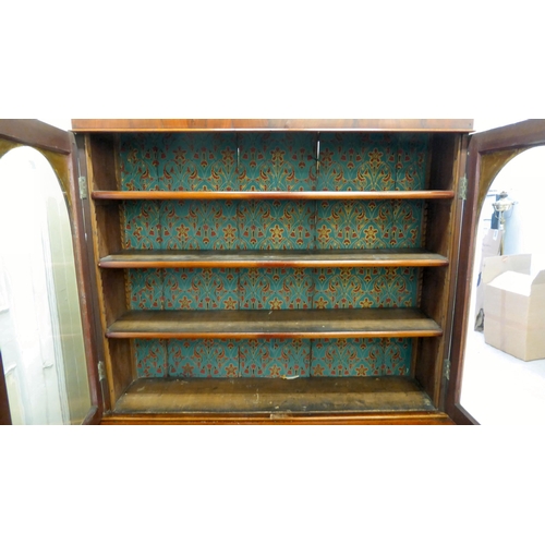 70 - A late Victorian mahogany finished cabinet bookcase, the upper section with two glazed doors, enclos... 