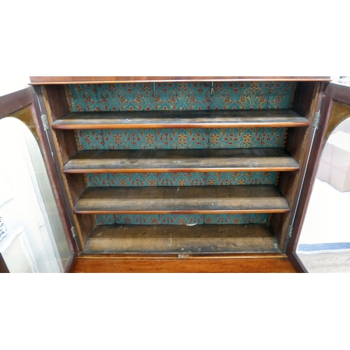 70 - A late Victorian mahogany finished cabinet bookcase, the upper section with two glazed doors, enclos... 