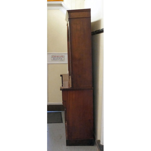 70 - A late Victorian mahogany finished cabinet bookcase, the upper section with two glazed doors, enclos... 