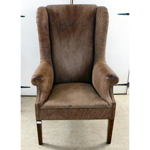 71 - An early 20thC Georgian reproduction of a stud upholstered, enclosed arm, high back chair, raised on... 