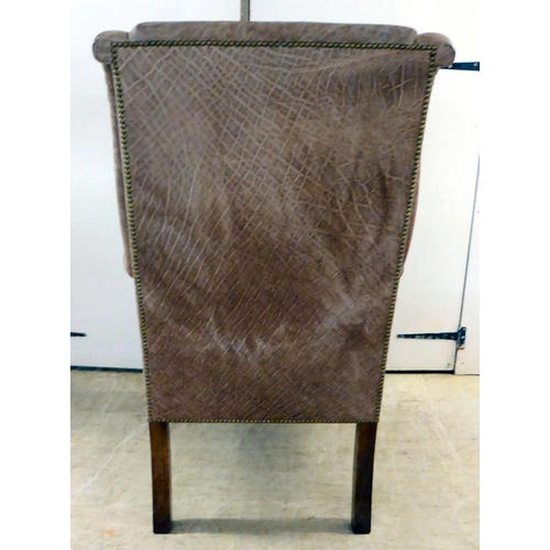 71 - An early 20thC Georgian reproduction of a stud upholstered, enclosed arm, high back chair, raised on... 