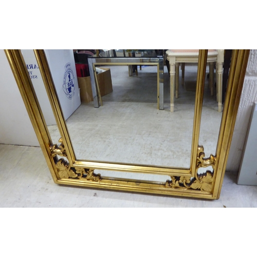 75 - A modern mirror, the segmented shaped plate set in a moulded gilt frame  42