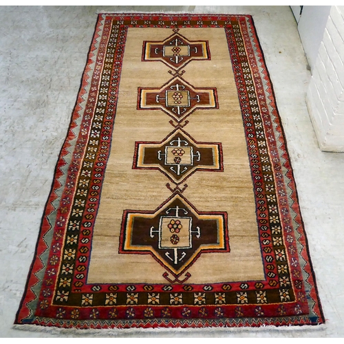 78 - A Turkish rug, decorated with repeating central designs and stylised border, on a multi-coloured gro... 