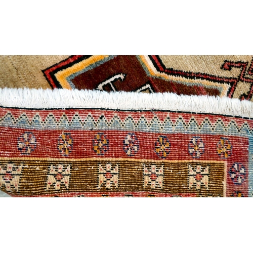 78 - A Turkish rug, decorated with repeating central designs and stylised border, on a multi-coloured gro... 