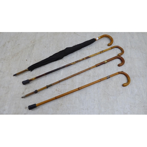 89 - Four wooden walking canes/umbrellas, one with a 9ct gold cap