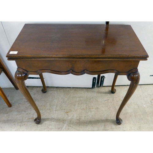 92 - An early 20thC mahogany card table, the foldover top raised on cabriole legs  29