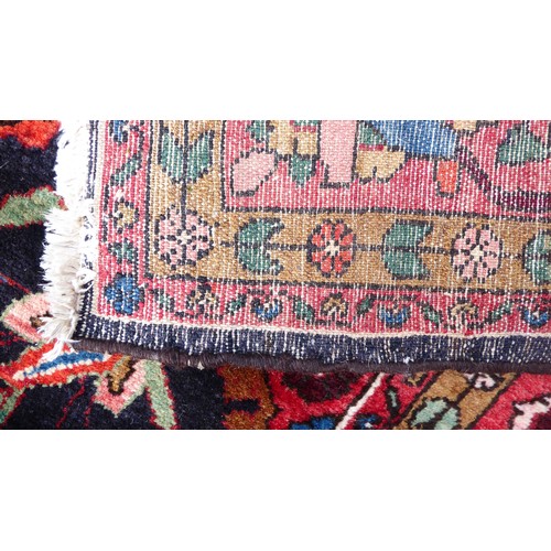 82 - A Persian carpet, decorated with floral and foliage designs, on a multi-coloured ground  94