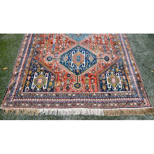 81 - A Shiraz carpet, profusely decorated with repeating stylised designs, on a multi-coloured ground  80... 