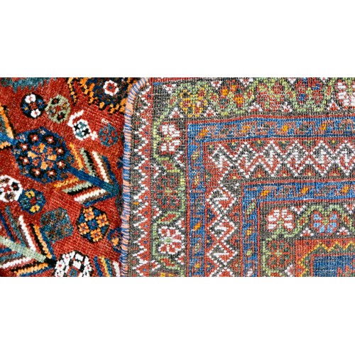 81 - A Shiraz carpet, profusely decorated with repeating stylised designs, on a multi-coloured ground  80... 