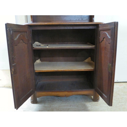 100 - An early 20thC oak two-part cottage dresser with two open shelves, over two panelled cupboard doors,... 