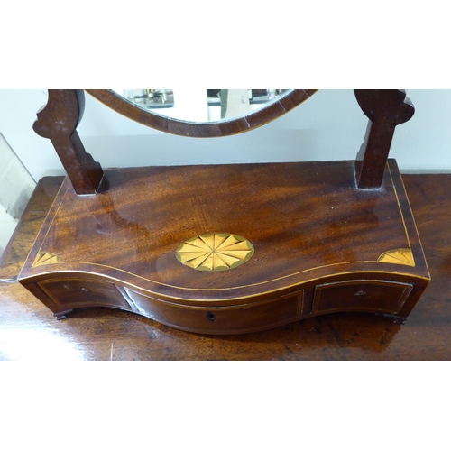 102 - A late George III string inlaid crossbanded, rosewood veneered dressing table mirror, the oval portr... 