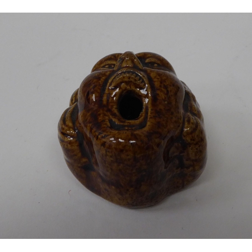 11 - A 19thC brown glazed pottery novelty pen holder, fashioned as a man's face with an open mouth 