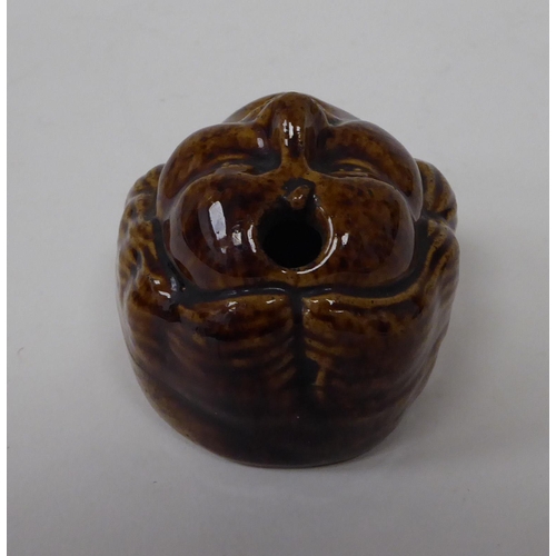 11 - A 19thC brown glazed pottery novelty pen holder, fashioned as a man's face with an open mouth 