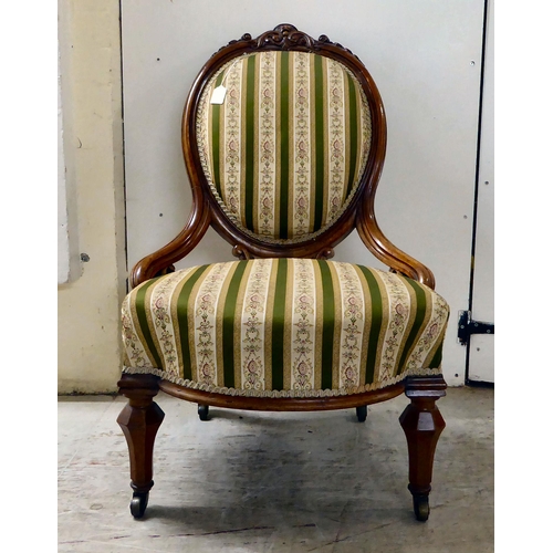 115 - A late Victorian walnut, showwood framed and later fabric upholstered nursing chair, raised on taper... 