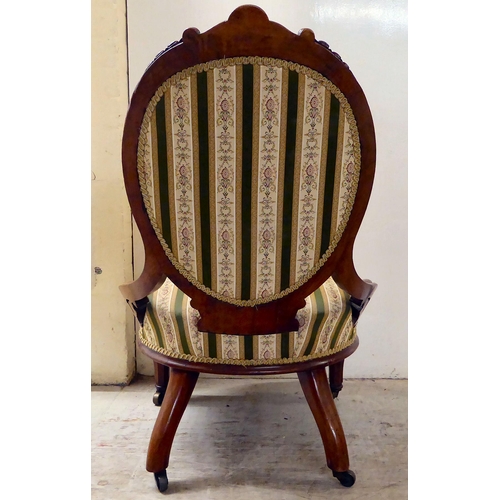 115 - A late Victorian walnut, showwood framed and later fabric upholstered nursing chair, raised on taper... 