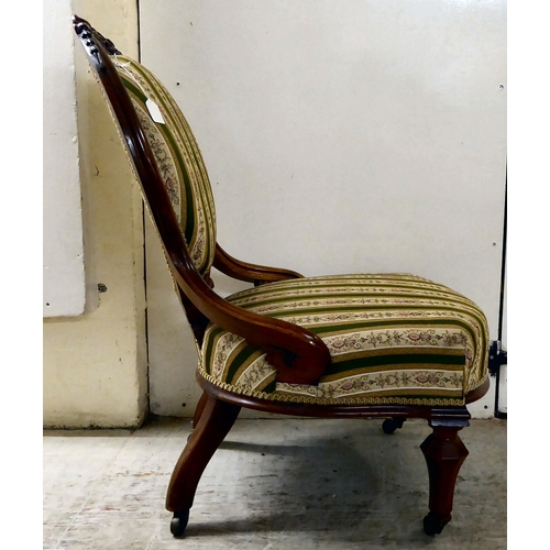 115 - A late Victorian walnut, showwood framed and later fabric upholstered nursing chair, raised on taper... 