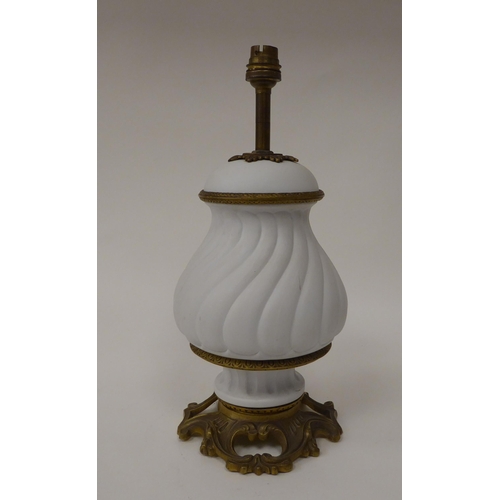 118 - An early 20thC off-white biscuit glazed ceramic vase design table lamp with gilded brass mounts, on ... 