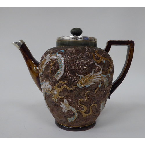 119 - A late Victorian Doulton Lambeth stoneware teapot of ovoid form with a silver collar and spout termi... 