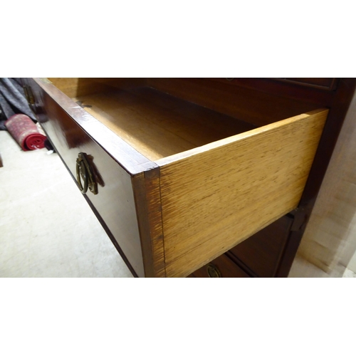 122 - A George III mahogany bachelor's chest with a brushing slide, over three drawers, raised on bracket ... 