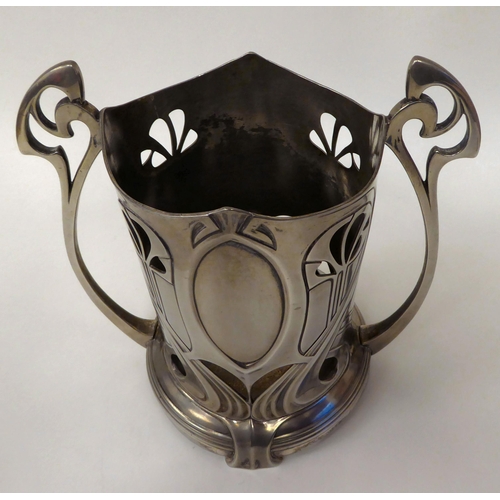 124 - An Art Nouveau pewter twin handled bottle coaster, decorated with typically flowing lines  bears imp... 