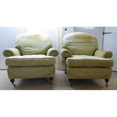 128 - A pair of modern floral patterned, old gold coloured fabric upholstered armchairs, raised on turned ... 