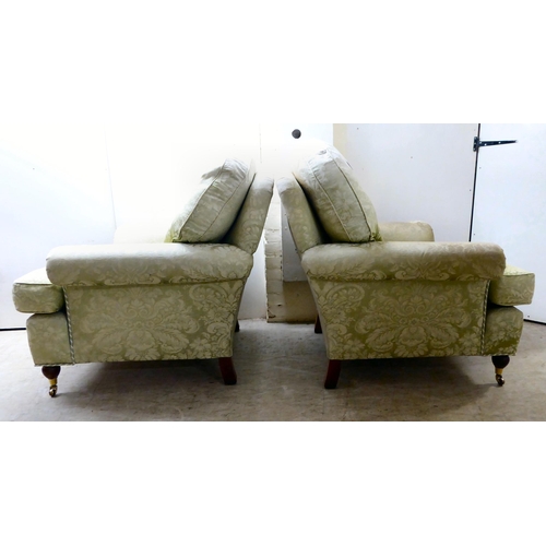 128 - A pair of modern floral patterned, old gold coloured fabric upholstered armchairs, raised on turned ... 