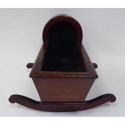 13 - An antique finished, mahogany miniature crib, fashioned as a planter, on a rocker base  18