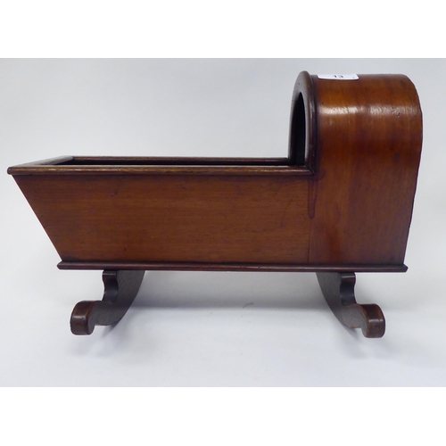 13 - An antique finished, mahogany miniature crib, fashioned as a planter, on a rocker base  18