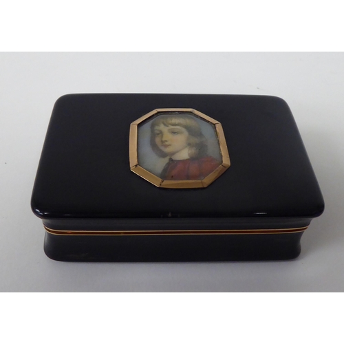 179 - A 19thC black stained horn snuff box with concave sides, a hinged lid and yellow metal mounts, displ... 