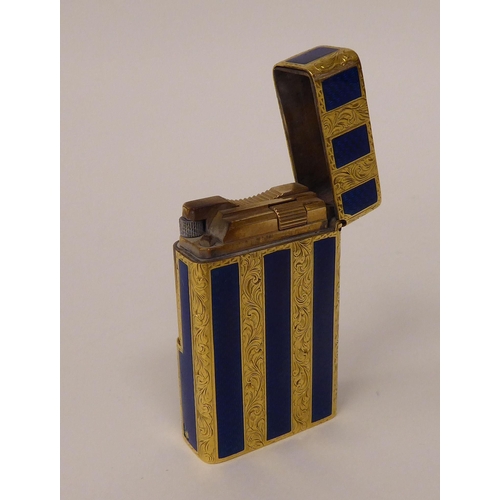 184 - A yellow metal and blue enamel, gas filled cigarette lighter with finely scroll engraved decoration