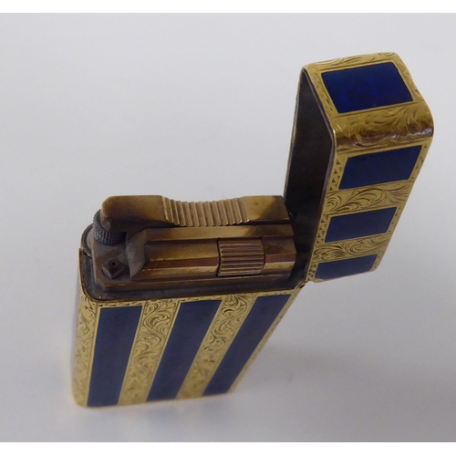 184 - A yellow metal and blue enamel, gas filled cigarette lighter with finely scroll engraved decoration