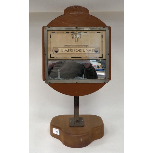 198 - An early 20thC deskstand ornament, comprising a strip mirror, below a printed paper banner, entitled... 