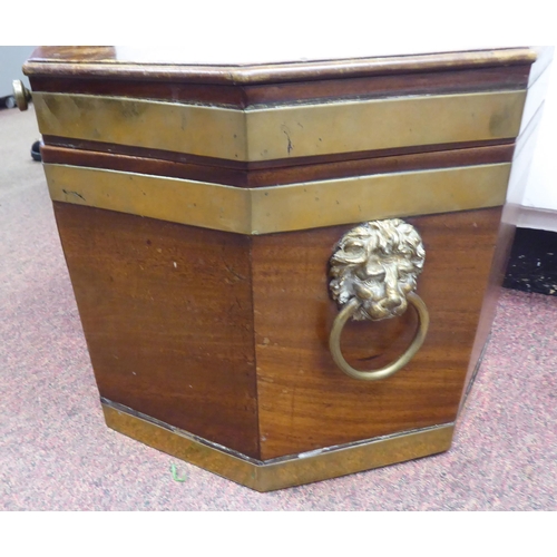 20 - A late Regency mahogany and brass bound, octagonal cellaret with twin lion mask handles, on a matchi... 