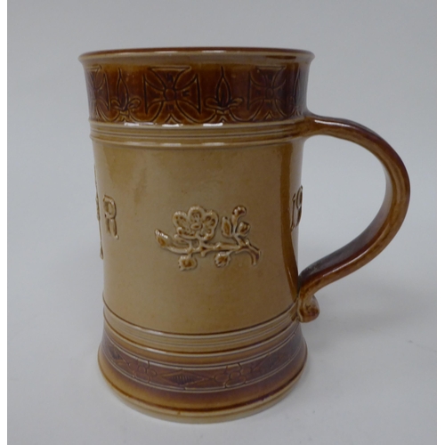 201 - A Doulton two tone brown stoneware mug, decorated to celebrate the Coronation of Queen Elizabeth in ... 