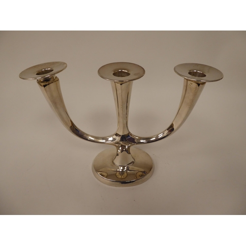 21 - A WMF white metal candlestand with three in-line sockets and detachable sconces, on an oval base&nbs... 