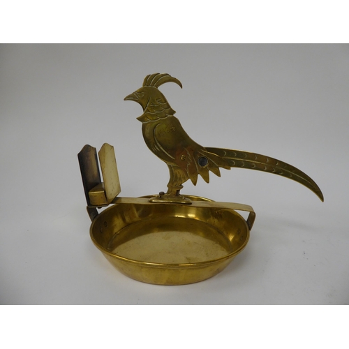 224 - A 20thC novelty brass combination cigar cutter and matchbox holder, fashioned as a bird on a saucer ... 