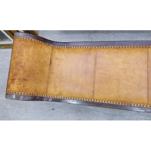 237 - A 20thC Asian hardwood framed window seat, stud upholstered in tan coloured hide, raised on splayed ... 