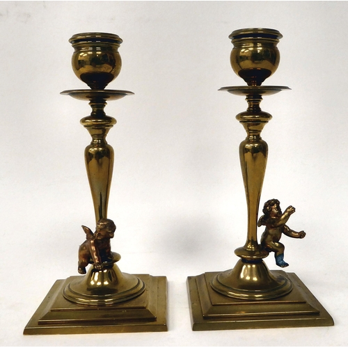 238 - A pair of late 19thC brass candlesticks with knopped, tapered stems, each surmounted by a cherubic f... 