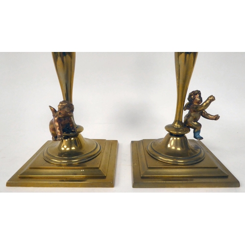 238 - A pair of late 19thC brass candlesticks with knopped, tapered stems, each surmounted by a cherubic f... 