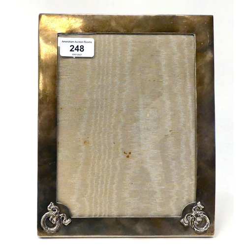 248 - A glazed, silver photograph frame with ribbon tied and wreathed ornament, on a fabric back and easel... 