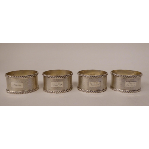 249 - A set of four silver, oval napkin rings with engine turned decoration  Birmingham 1966  (combined we... 