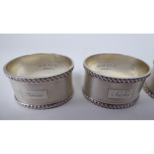 249 - A set of four silver, oval napkin rings with engine turned decoration  Birmingham 1966  (combined we... 