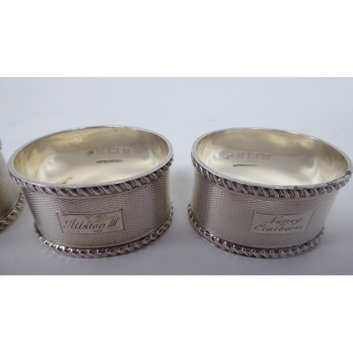 249 - A set of four silver, oval napkin rings with engine turned decoration  Birmingham 1966  (combined we... 