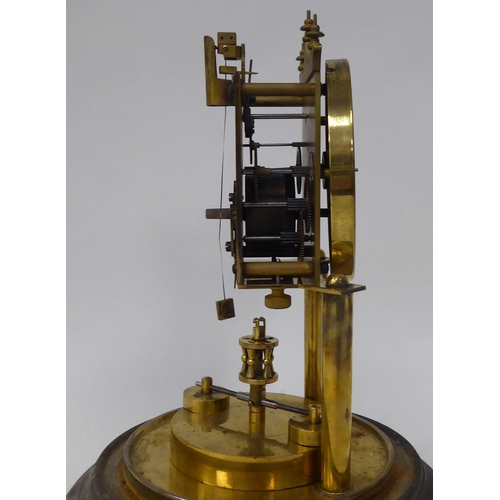 25 - An early 20thC lacquered brass cased torsion timepiece with an exposed mechanism, faced by a white e... 