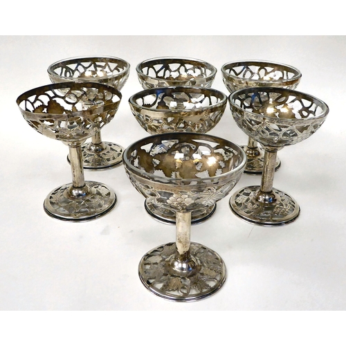 250 - A set of seven Sterling silver sweet dishes with integral glass liners (one broken), the bowls decor... 