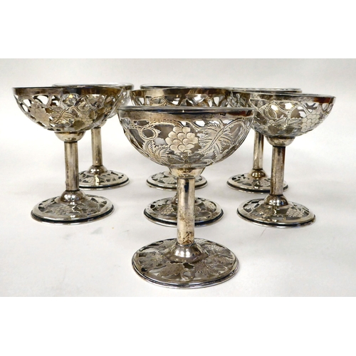 250 - A set of seven Sterling silver sweet dishes with integral glass liners (one broken), the bowls decor... 