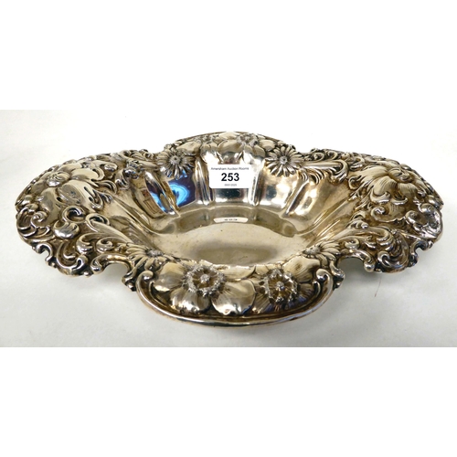 253 - A Sterling silver oval dish, the wide rim embossed with flora and scrolls  12